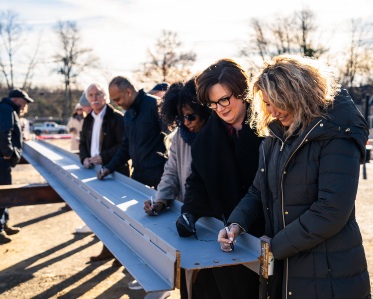 Y board members signing final steel beam